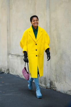 MILAN, ITALY - SEPTEMBER 24: Tamu McPherson wears gold pendant earrings, a dark green wool polo shir...