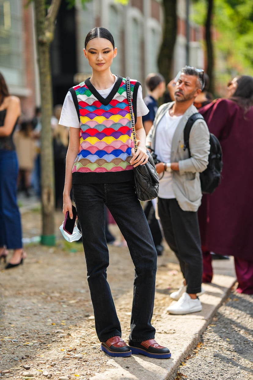 MILAN, ITALY - SEPTEMBER 22: A guest wears a white t-shirt, a multicolored flashy print pattern V-ne...