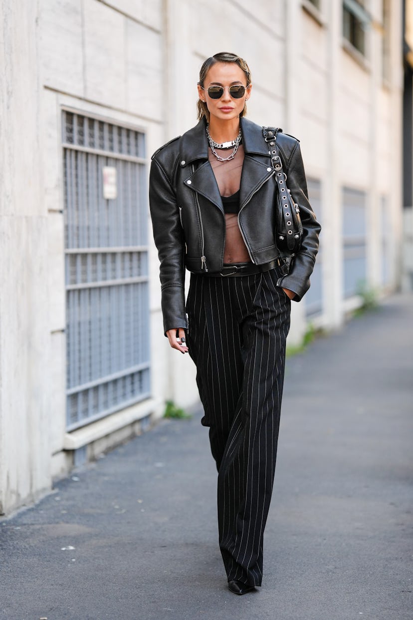 MILAN, ITALY - SEPTEMBER 22: A guest wears black sunglasses from Ray Ban, silver earrings, silver ha...