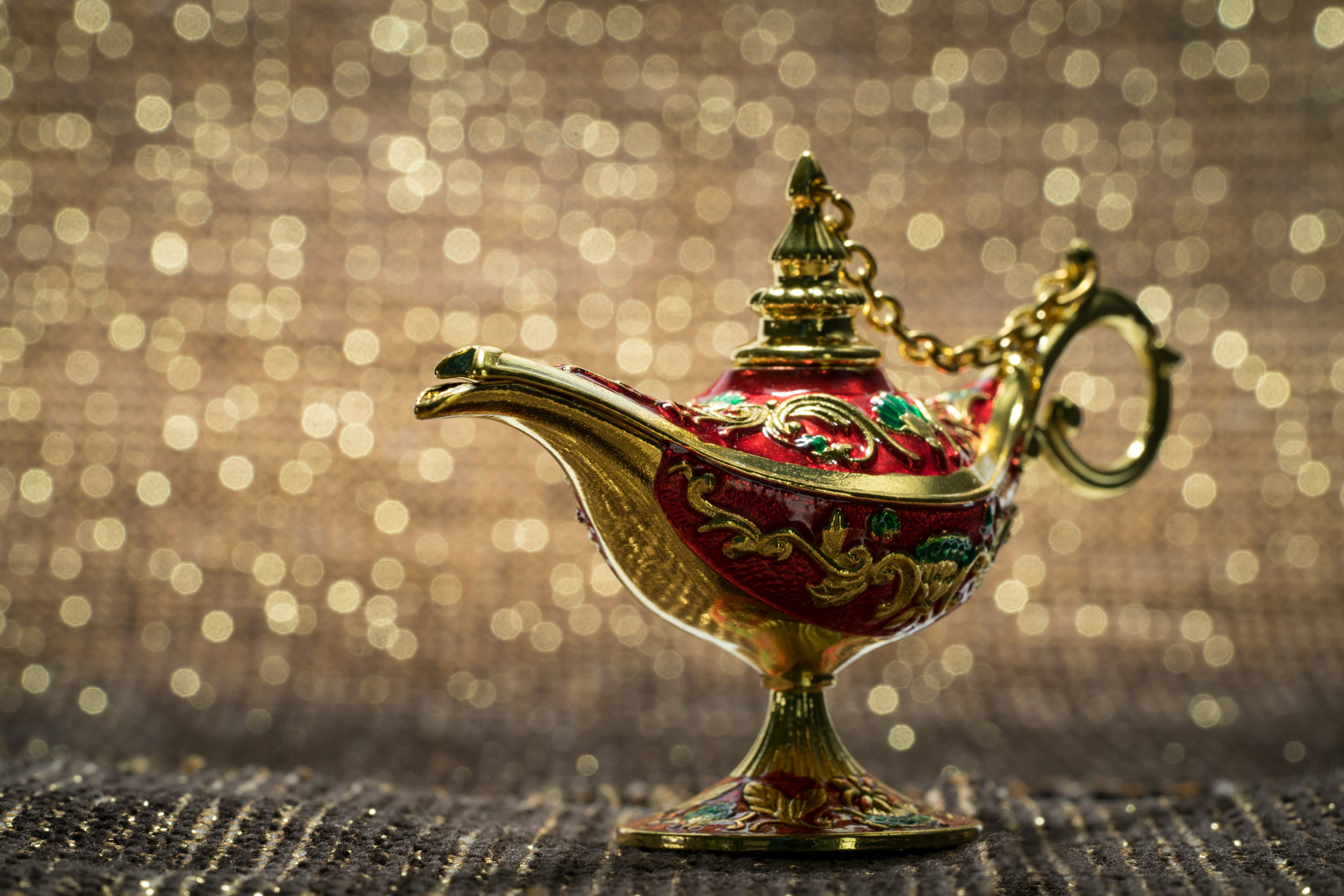 Close-Up Of Magic Lamp on fabric against golden bokeh background