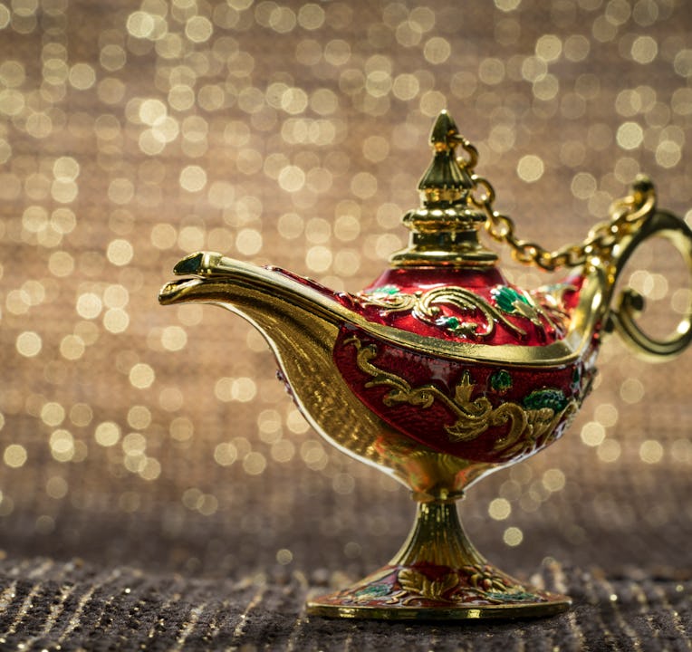 Close-Up Of Magic Lamp on fabric against golden bokeh background