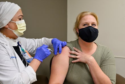 Orange, CA - August 19: Nurse Mary Ezzat administers a Pfizer COVID-19 booster shot to Jessica M. at...