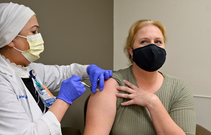 Orange, CA - August 19: Nurse Mary Ezzat administers a Pfizer COVID-19 booster shot to Jessica M. at...