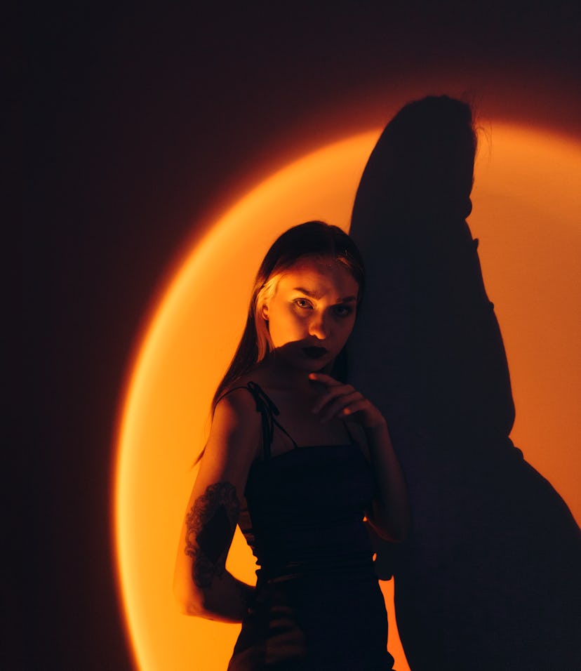 The 2021 new moon in Scorpio on Nov. 4 — the first new moon after Halloween — illuminating a woman.