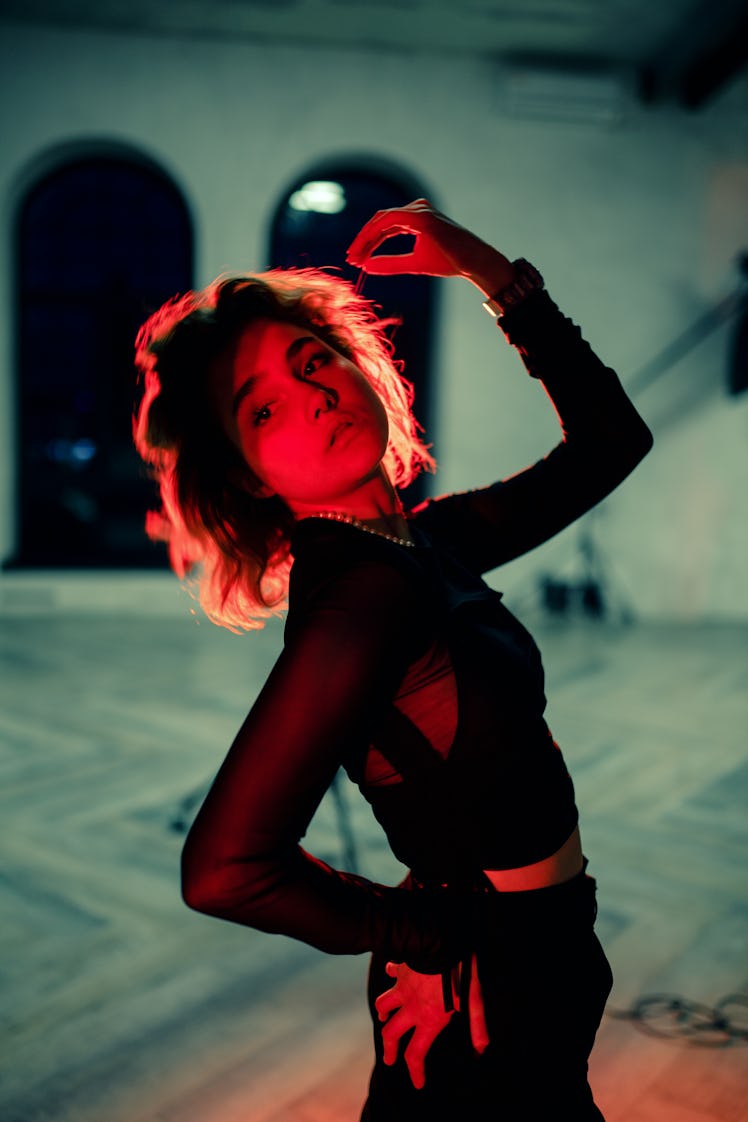 Young woman in red neon light during the October 2021 full moon in Aries, which will affect her zodi...