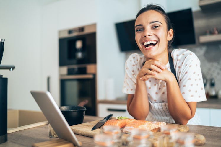A woman makes salmon at home in order to make the salmon rice bowl viral TikTok recipe.