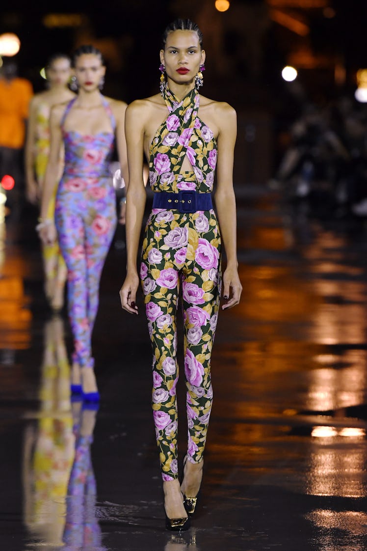 A model walking in a floral purple-yellow jumpsuit Saint Laurent dress on the runway