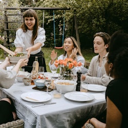 A group of friends sitting at a table and attending a dinner party on a dime