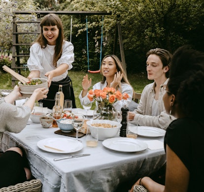 A group of friends sitting at a table and attending a dinner party on a dime