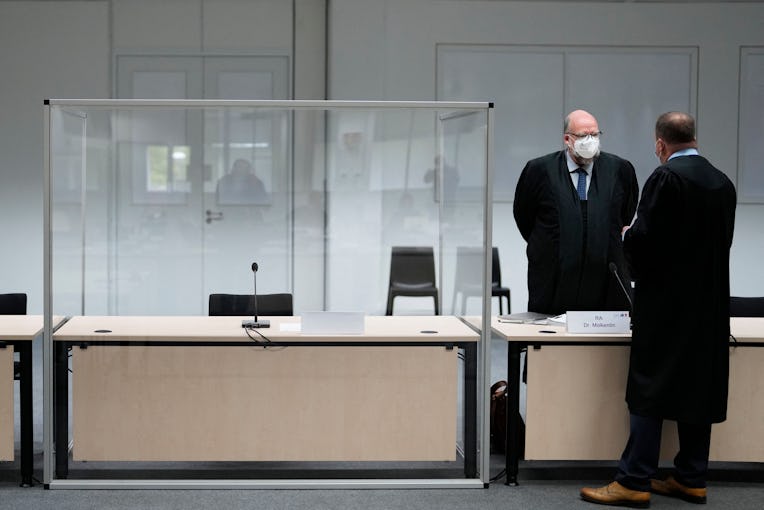 Two lawmakers stand next to an empty seat of the defendant at the courtroom, prior to a trial agains...