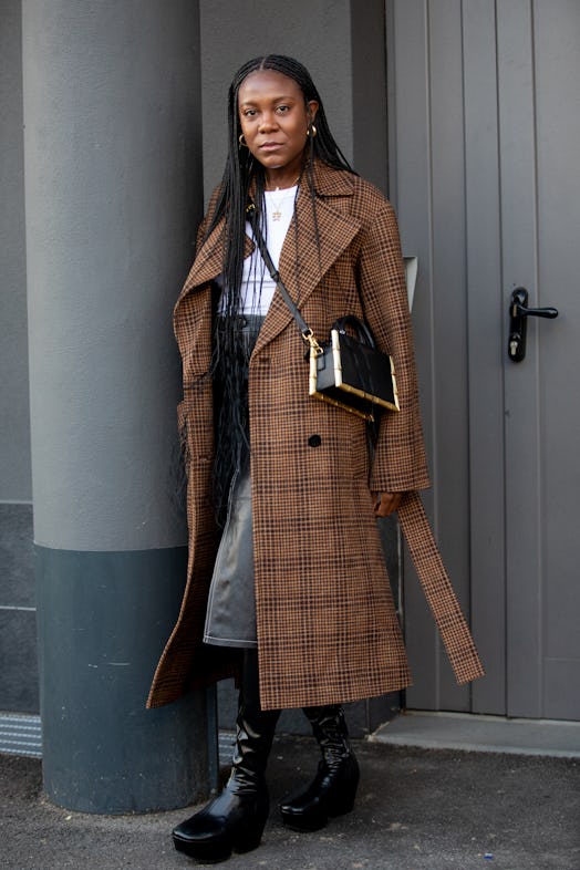 MILAN, ITALY - SEPTEMBER 24: A guest outside Missoni fashion show wearing a checkered coat, black bo...