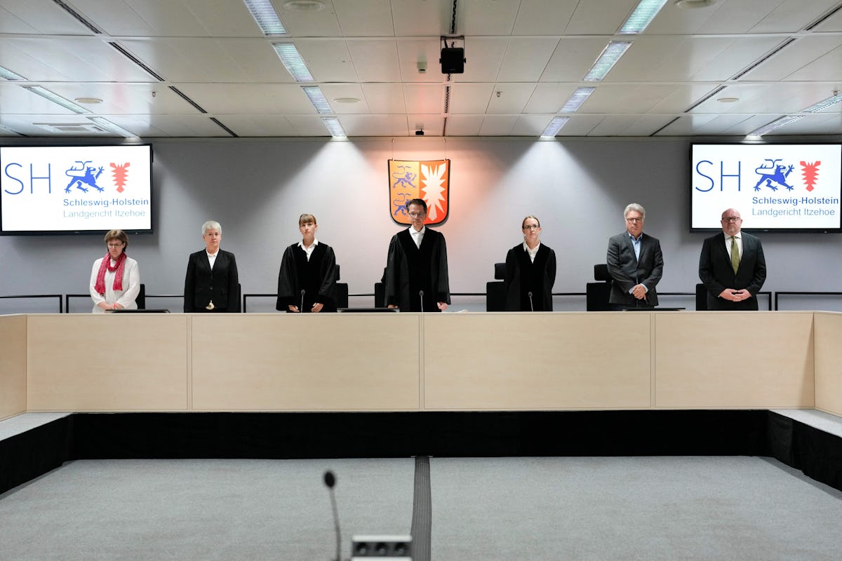 Presiding judge Dominik Gross (C) and the judges pose for the media after arriving for a trial again...