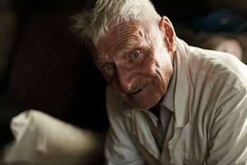 An elderly man looking  at the camera and smiling