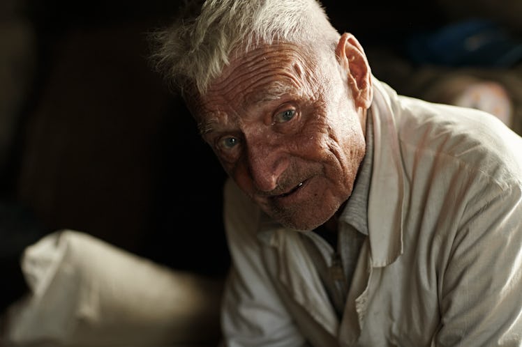 An elderly man looking  at the camera and smiling