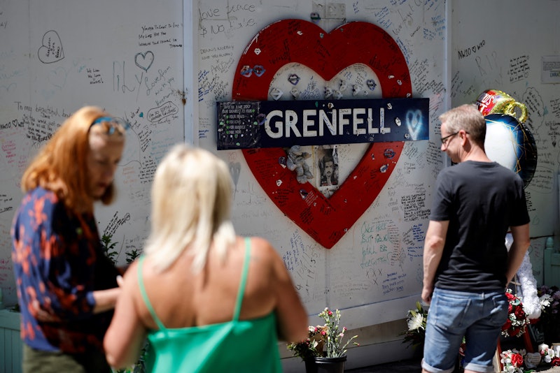 People look at a memorial to the victims of the Grenfell Tower fire, in west London on June 14, 2021...