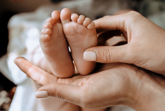 a woman's hands holding baby's feet