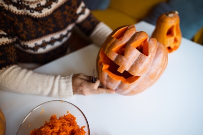 Carving pumpkins at home is a fun Halloween date idea. 