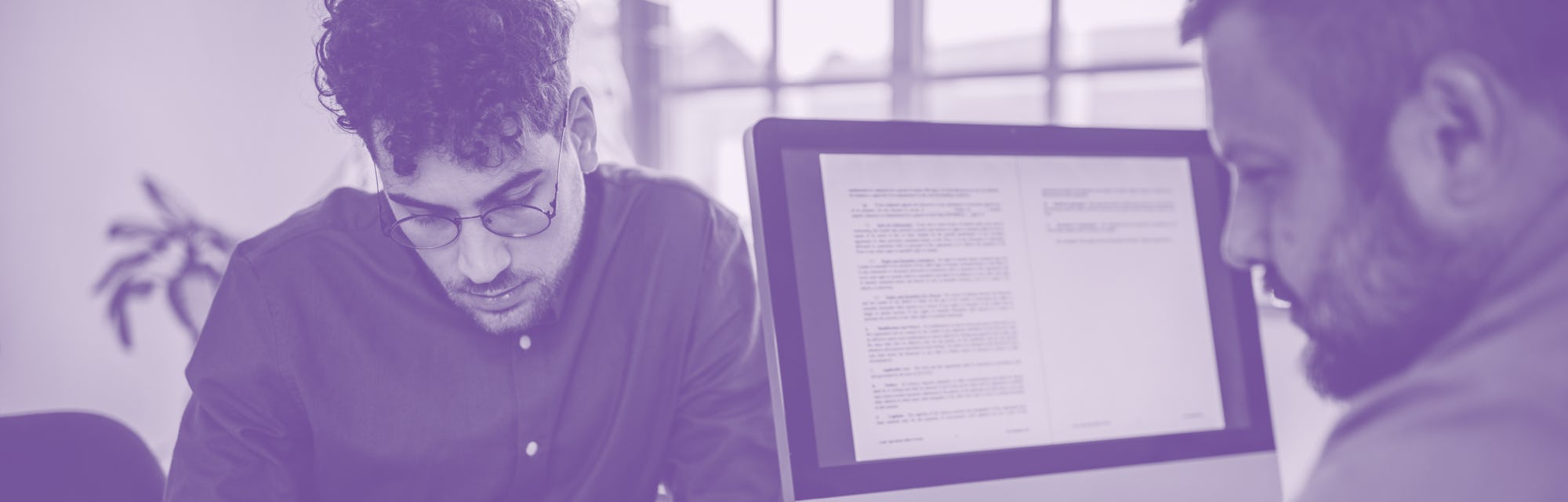 Two people, young man on a job interview in modern office. Male manager is interviewing him.