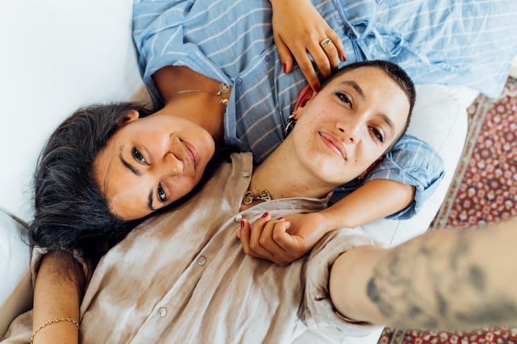 two women hugging as they lay down and gaze into the camera, reflecting on their libra cancer friend...