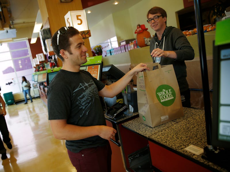 Leo Romanovsky (l to r), of San Francisco collects his purchases from Ethan Bridges, cashier,  after...