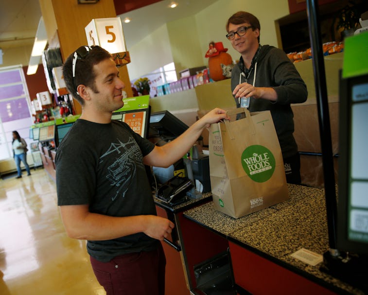 Leo Romanovsky (l to r), of San Francisco collects his purchases from Ethan Bridges, cashier, after...