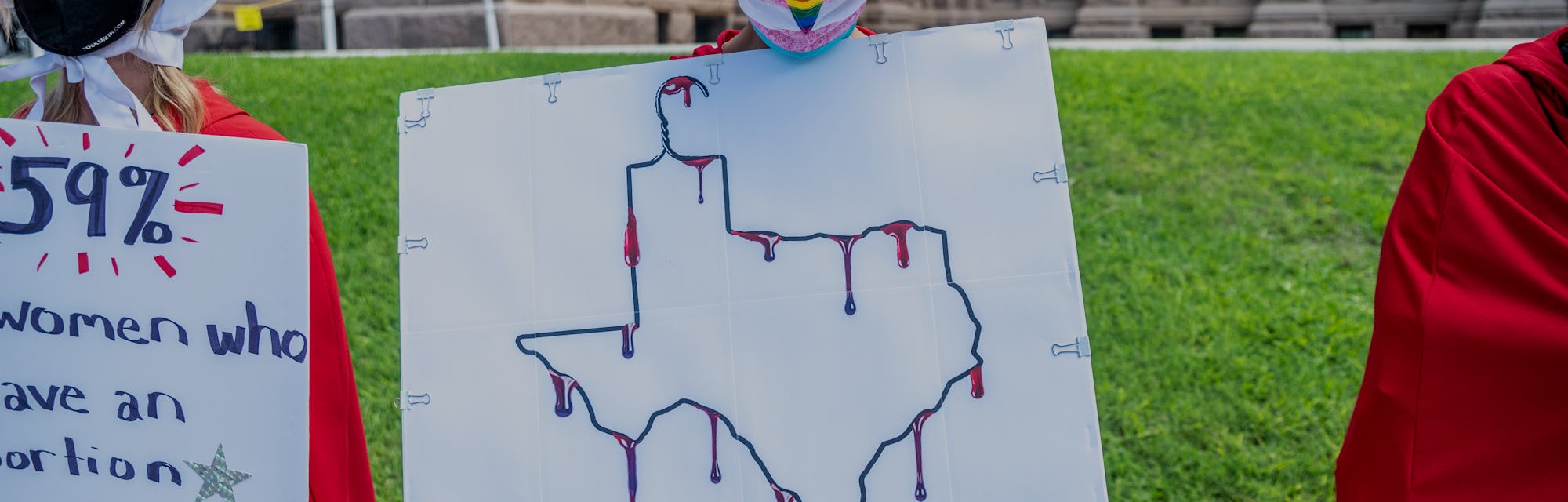 AUSTIN, TX - MAY 29: A protester dressed as a handmaiden holds up a sign at a protest outside the Te...