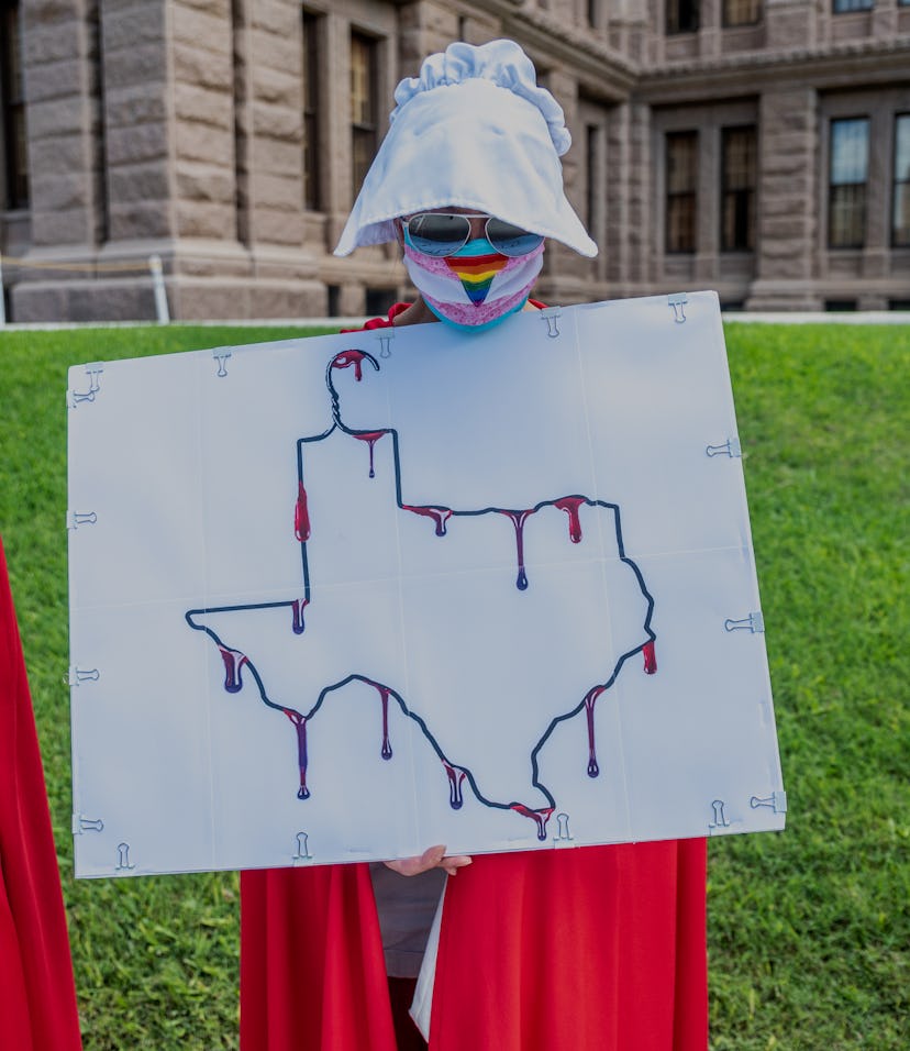 AUSTIN, TX - MAY 29: A protester dressed as a handmaiden holds up a sign at a protest outside the Te...