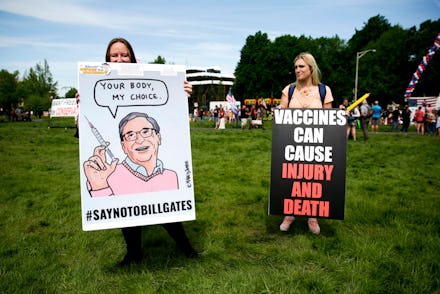 Two women hold anti-vaccination signs during a protest against Governor Jay Inslee's stay-at-home or...