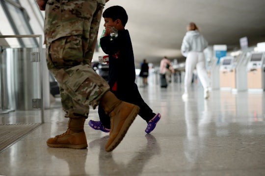 DULLES, VIRGINIA - AUGUST 31: An Afghan boy walks with a U.S. service member as he and his family ar...