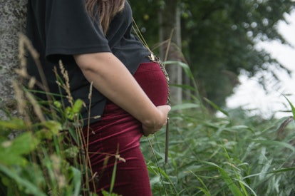 Pregnant woman in a photo shoot, standing in a typical  Friesland landscape