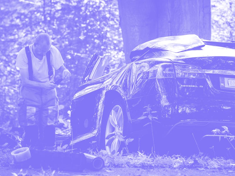 A rescue worker takes a picture around the spot where a Tesla slammed into a tree in Baarn, on Septe...