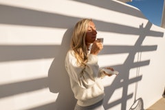 A woman drinks coffee while in the shadow of a trellis. Here's how the january 2022 full moon will a...