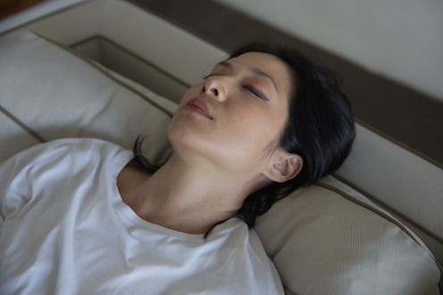 Close-up shot of a Malaysian woman closing her eyes and resting her throbbing head due to migraine o...