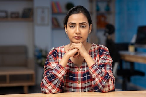 Woman sitting at the table in deep thought