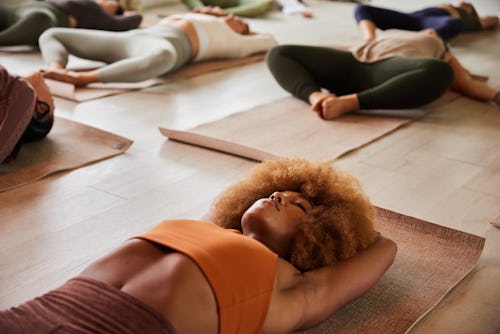 A woman lies in savasana at the end of yoga class. Here's your daily horoscope for January 11, 2022.