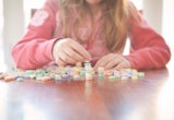 little girl stacking conversation hearts for a valentine's day game for kids idea