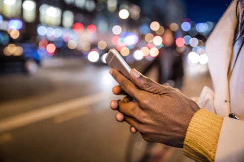 Woman texting while waiting on the street