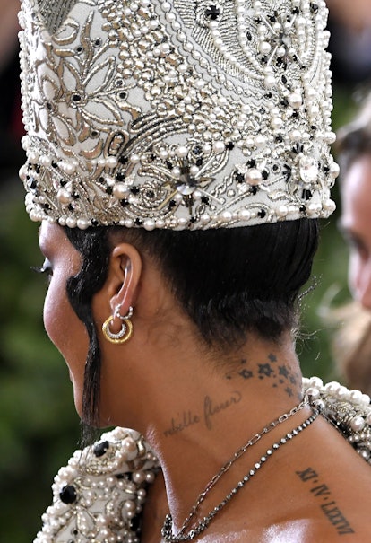 Rihanna has a neck tattoo that reads rebelle fleur. 