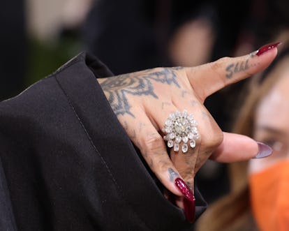 Rihanna a plusieurs tatouages ​​sur les mains.  L'un d'eux est un doigt et lit "chut..."