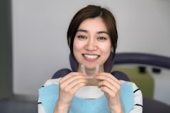 Young female holding an invisible dental aligner