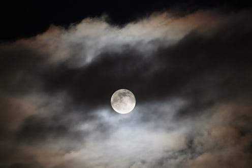 The full moon of January is rising on the dramatic cloudscapes.