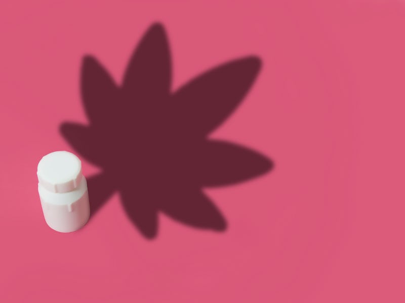 Illustration of a medicine bottle that casts a shadow of a marijuana leaf on a pink background with ...