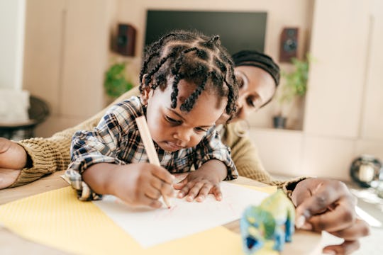 Toddler drawing while mom watches, demonstrating perfectionistic ways, a fascinating fact about Virg...