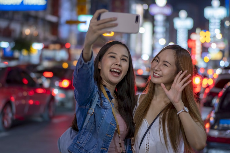 Two young women traveling in Bangkok at night