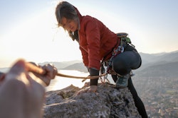 A woman climbs up a mountain. These are capricorn zodiac sign's biggest strengths, including being r...