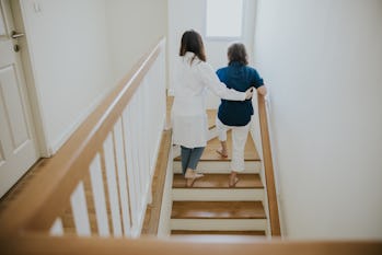 Illness, illness prevention, senior woman, doctor, holding hands, support, moving up, staircase, wal...