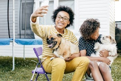 Teen and her little sister taking photos with puppies