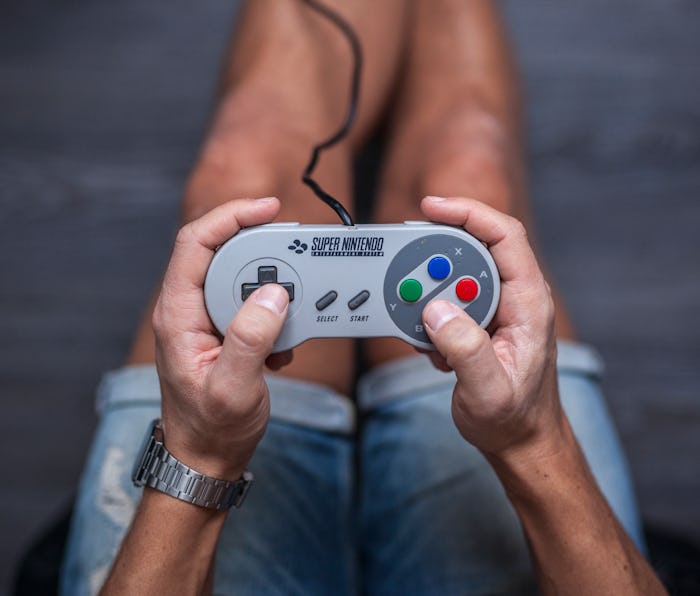 Gothenburg, Sweden - January 31, 2015: A shot from above of a young man's hands using a Super Ninten...