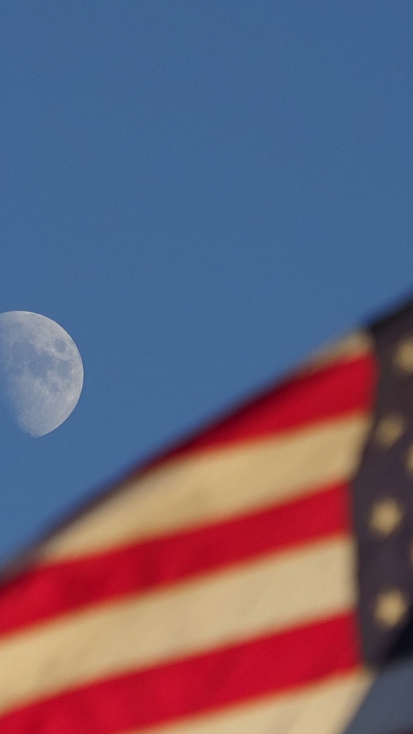 The United State's flag waving in the sky with the moon in the background. The United State's first ...