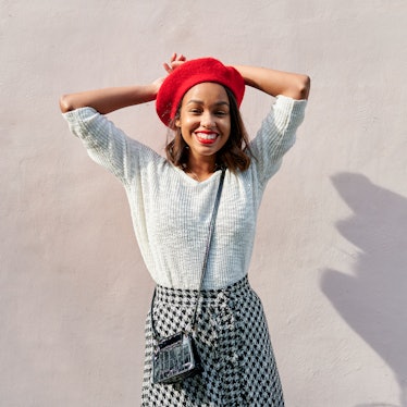 Young woman wearing a red beret and smiling, thinking about how January 24, 2022 will be the best we...